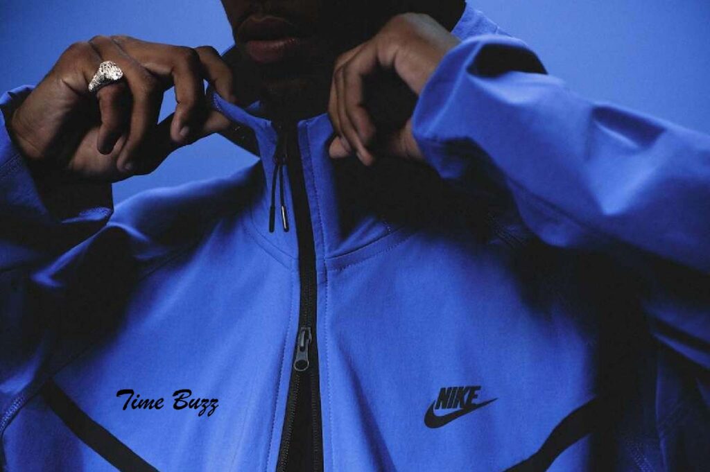 Tech Fleece Innovations: Stay Warm, Dry & Lightweight Man wearing a modern tech fleece hoodie outdoors in winter.